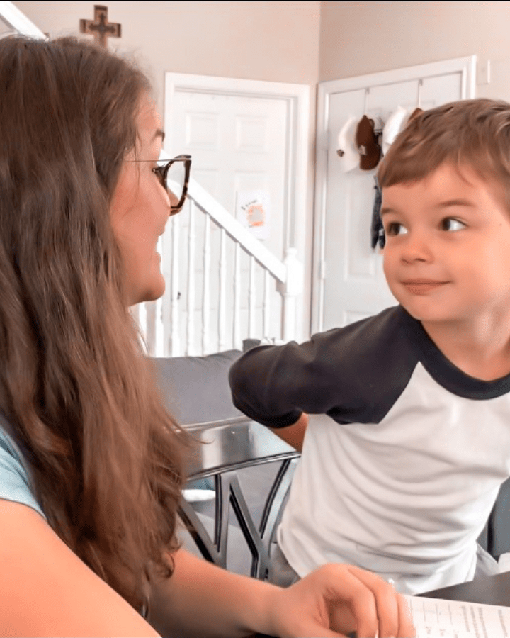 woman homeschooling her son at the kitchen table