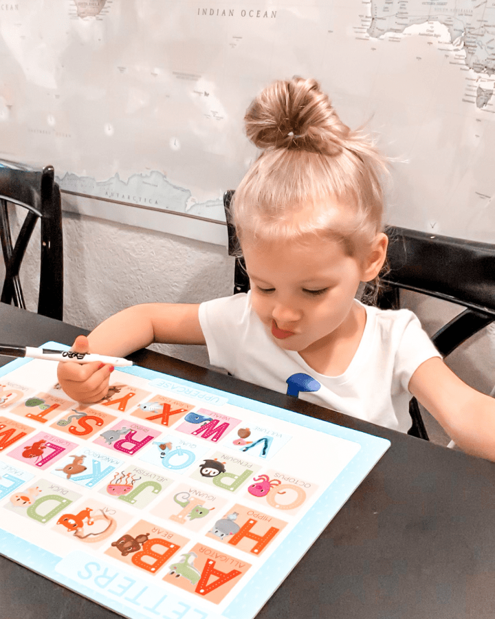 little girl at the kitchen table identifying alphabet letters