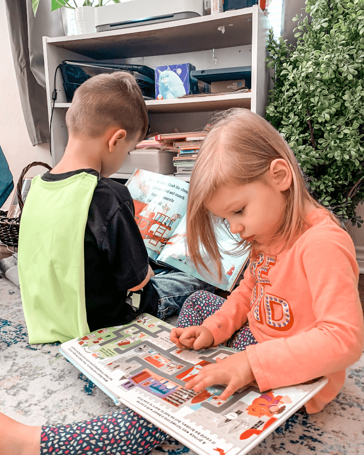a boy and a girl each reading a book next to each other
